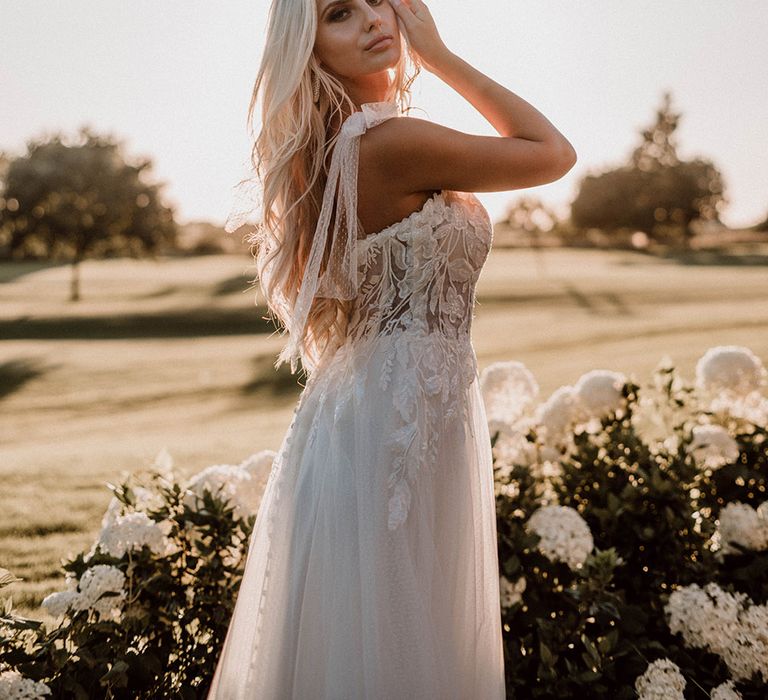 Bride in a lace and polka dot tulle wedding dress standing in the sunlight at Pryors Hayes wedding venue 