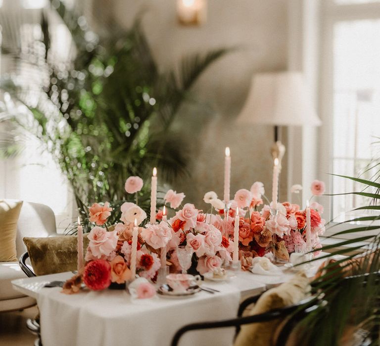 Luxe pink and peach wedding flowers tablescape at Amadria Park Hotel, with tapered candles and palm trees