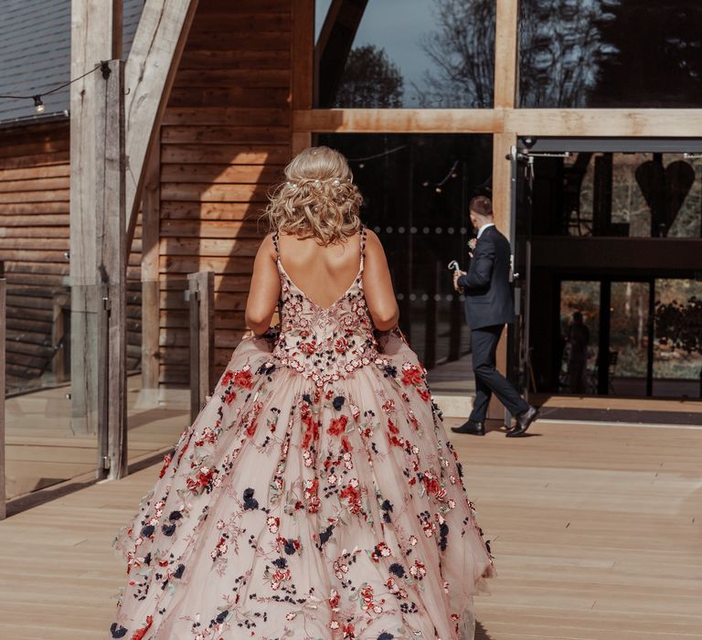 Bride walks to wedding venue whilst lifting bridal gown