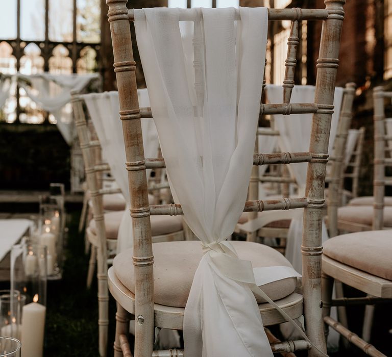 Wooden chairs with fabric chair back decor tied over the back 