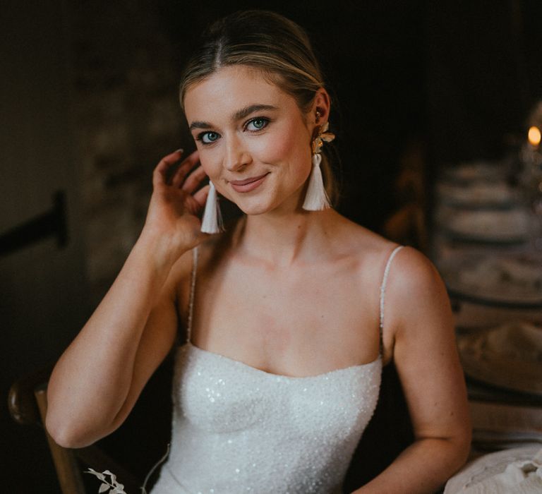 Bride in a sparkly wedding dress with tassel earrings 