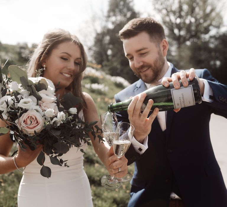 Bride and groom pouring their first glass of champagne as husband and wife