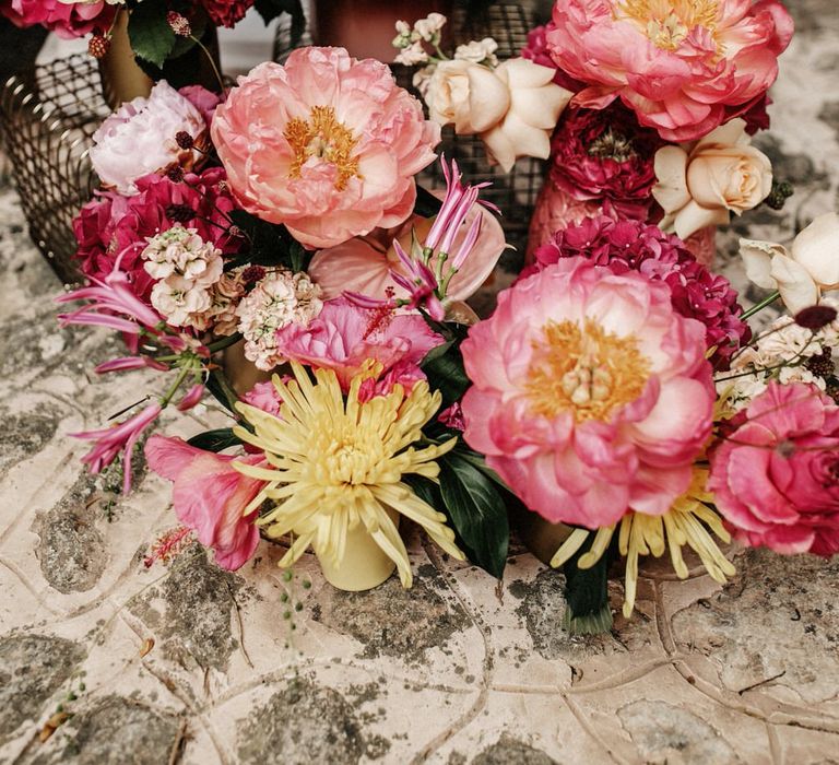 Bright pink floral installations with yellow flower details, including peonies, hydrangeas, dahlias, roses and wildflowers