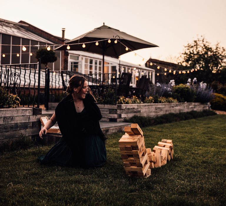 Wedding guest plays giant jenga on the lawn for garden games