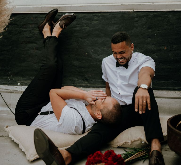 Grooms laughing with each other at New York rooftop wedding