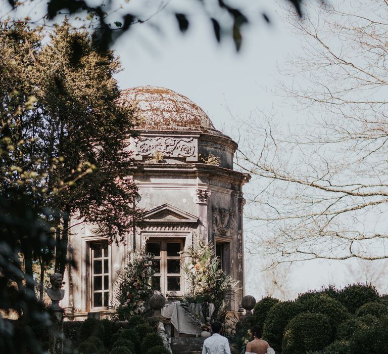 Bride and groom walking through the The Larmer Tree gardens 