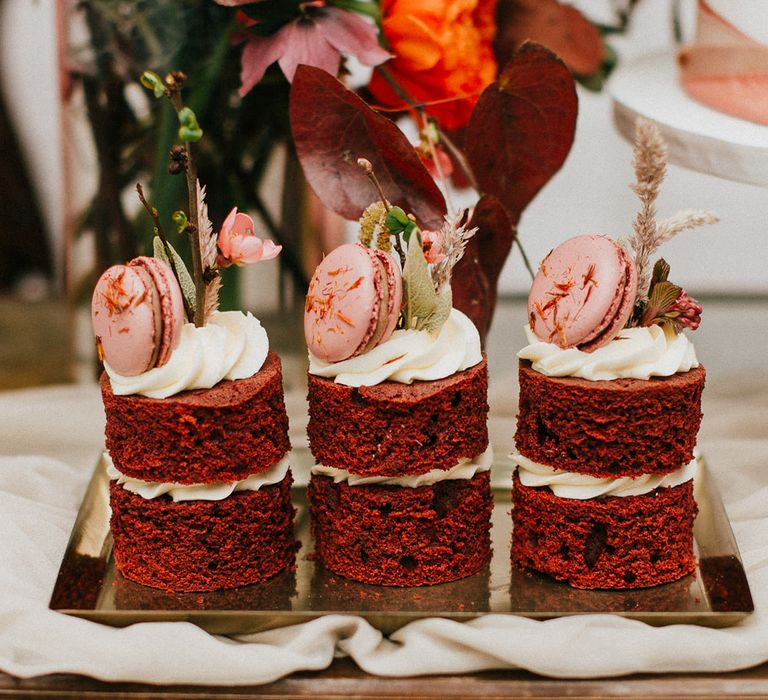 Red velvet mini sandwich cakes topped with pink macaroons 