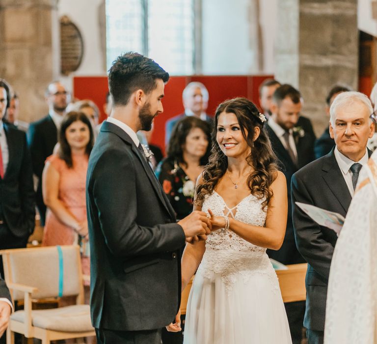 Bride & groom look at one another on their wedding day during church ceremony