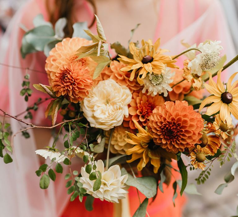 Orange and yellow dahlia and wildflower wedding bouquet 