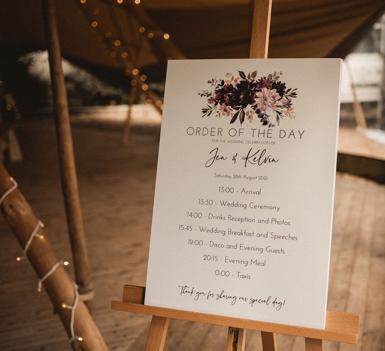 White order of the day sigh on wooden easel in tipi at Inkersall Grange Farm for tipi wedding reception