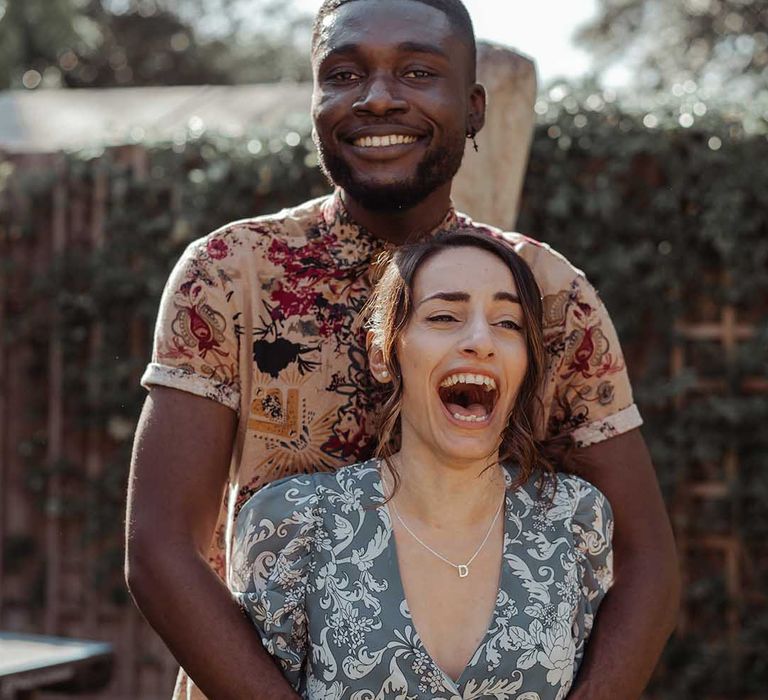 Wedding guests laugh with one another outdoors 