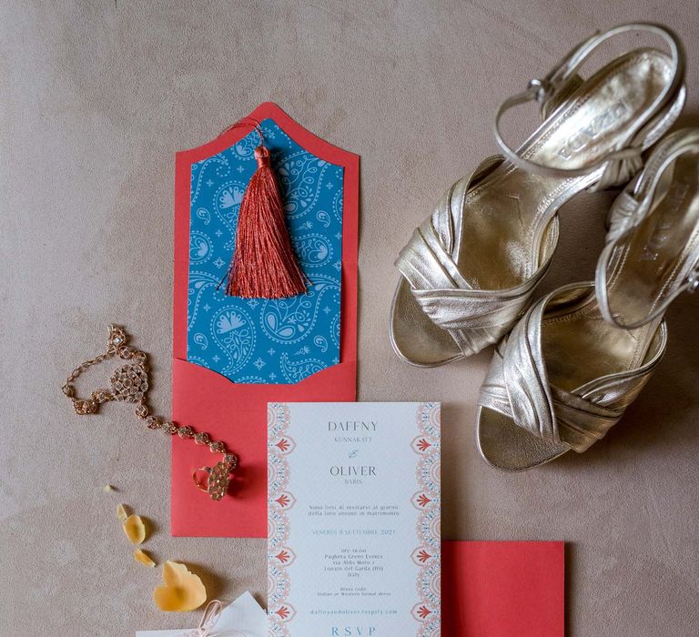 Hot pink and white stationery surrounded by colourful rose and gold wedding shoes