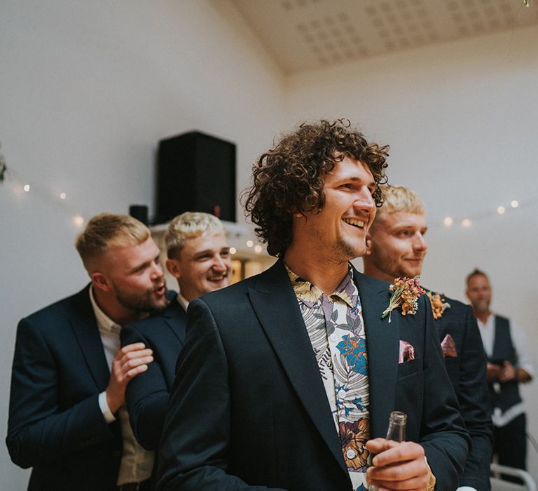 Groom looks down the aisle toward his bride on his wedding day