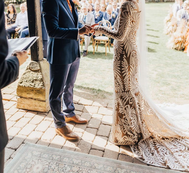 Barn wedding Groom in Navy fitted suit with burnt orange tie & bride in lace boho dress 