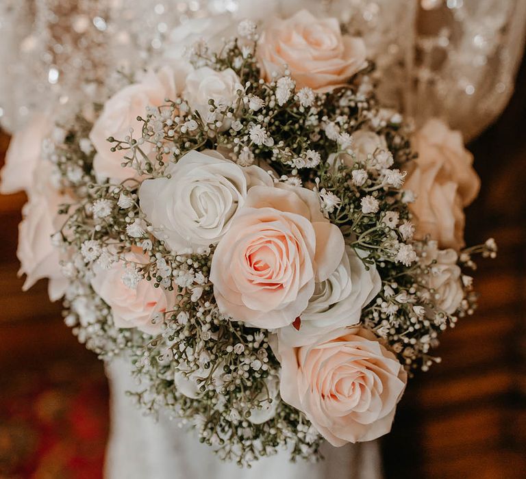 Bride holds rose bouquet complete with white & pink florals