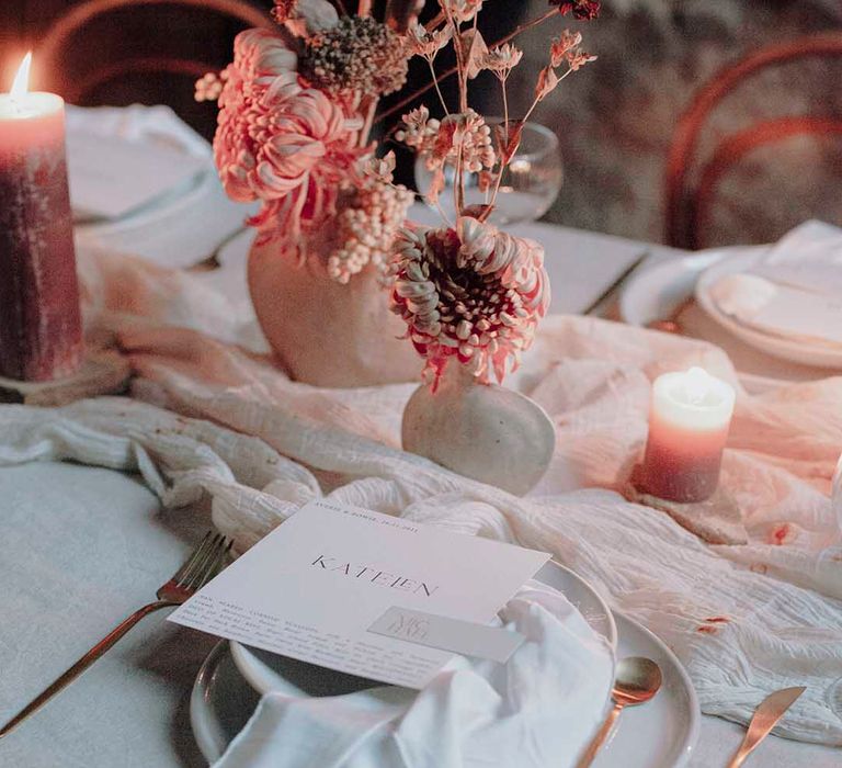 Place setting with fabric table runner, pillar candles, dried flower centrepieces and modern on the day stationery 