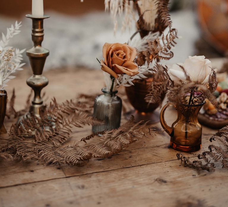 dried flower stems in vessels and illustrated candles 