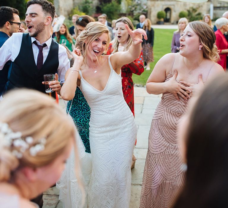 Bride in a white beaded Made With Love wedding dress dancing outside 