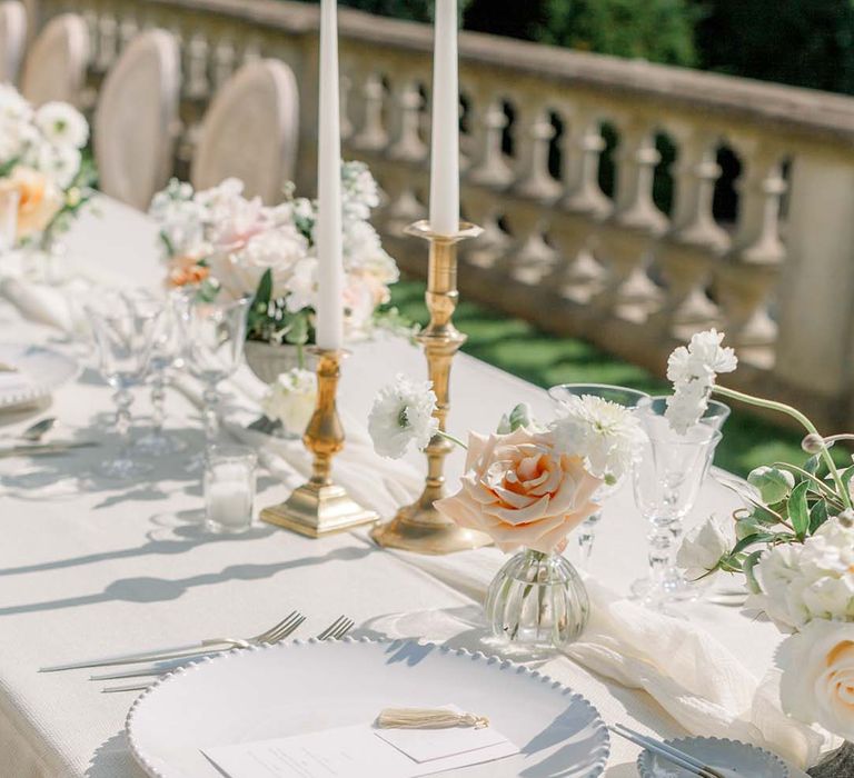 Simple tablescape complete with white plates and pastel floral bouquets 