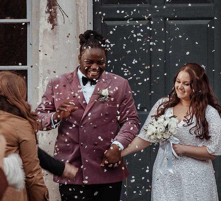 Bride & groom leave ceremony as wedding guests throw confetti around them