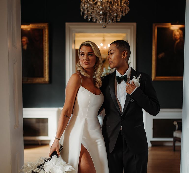 LGBTQI+ couple in a tuxedo suit and princess wedding dress with front slit and pearl wedding shoes at Hodsock Priory 