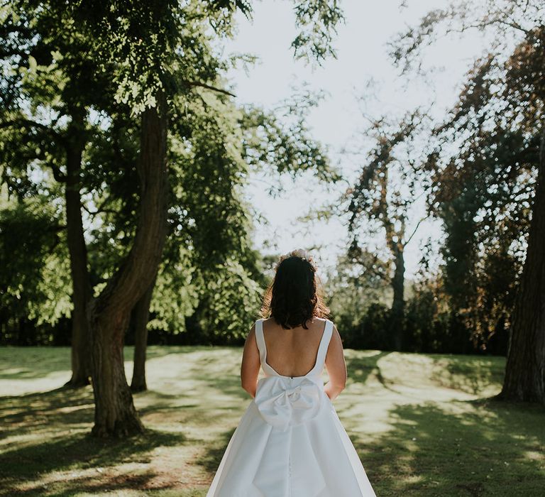 Bride in scoop back style Stella York wedding dress with custom added bow