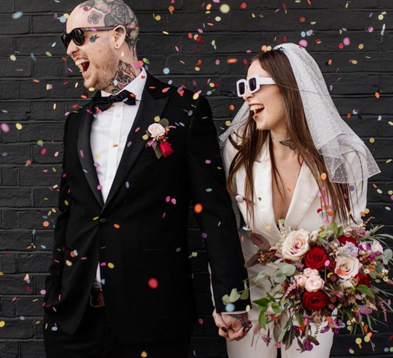 Confetti moment at Brighton micro wedding with bride and groom in wedding sunglasses 