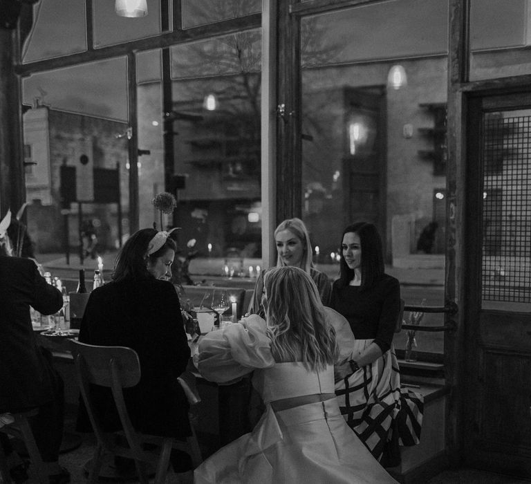 Bride in JESUS PEIRO bridal separates leaning down talking to her guests at her reception 