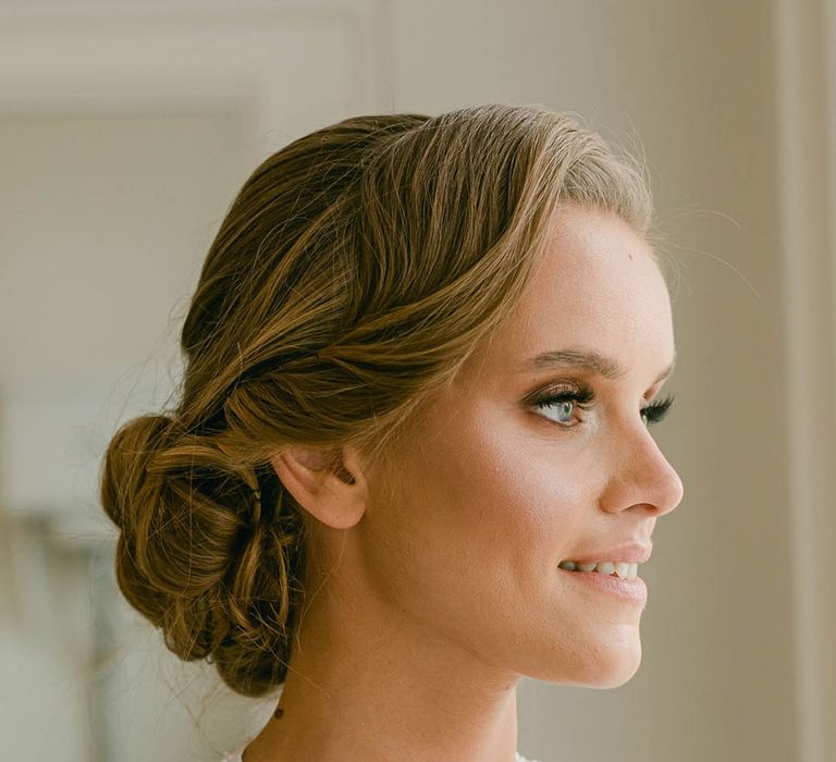 Bridal updo hairstyle with glam and glowy makeup in sparkly number 