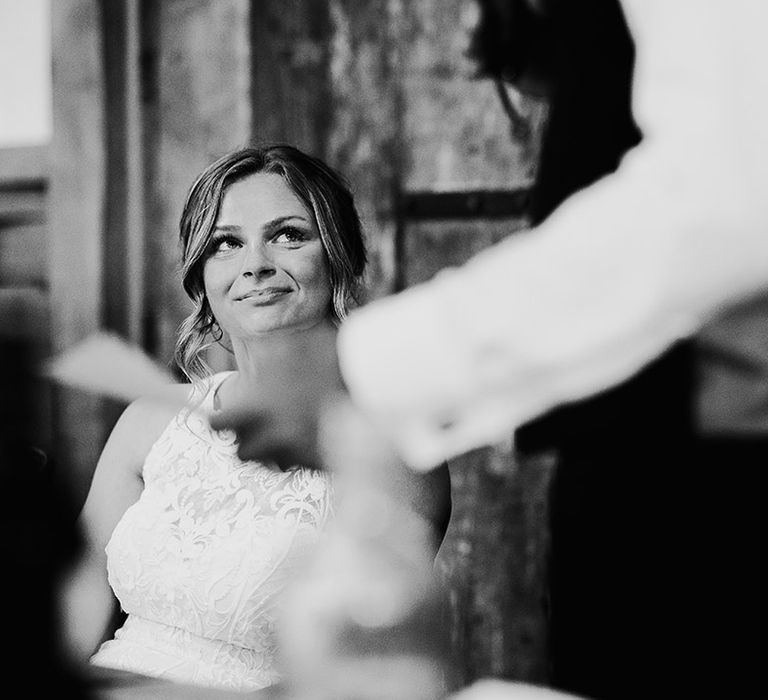 Bride looks up at wedding guest giving a speech 