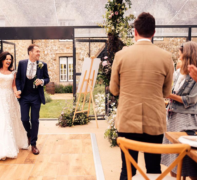 Bride and groom walk into their wedding reception 