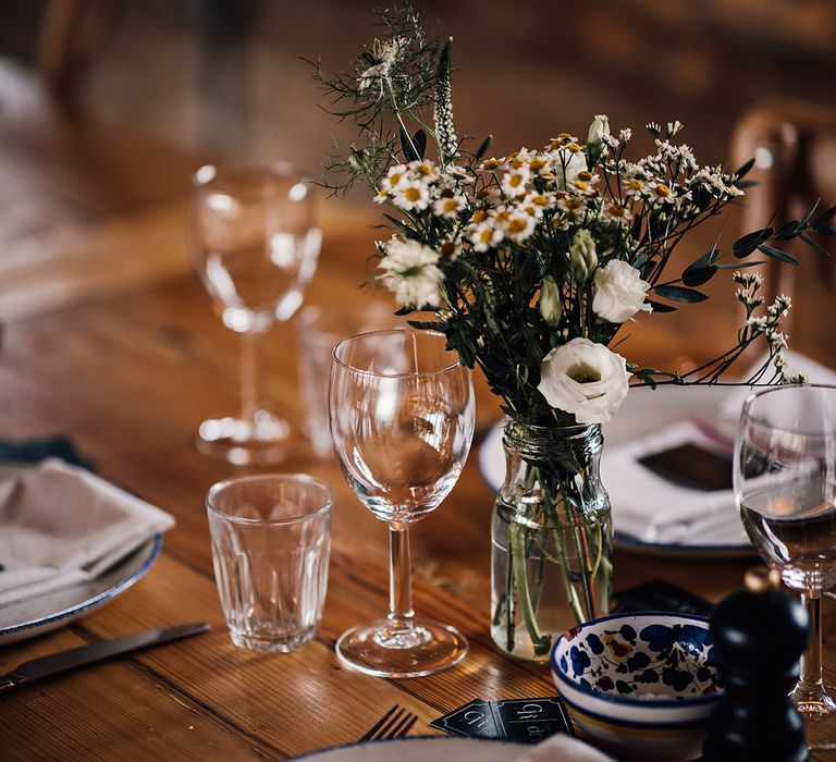 Blue and white plates with a small flower arrangement of white flowers 