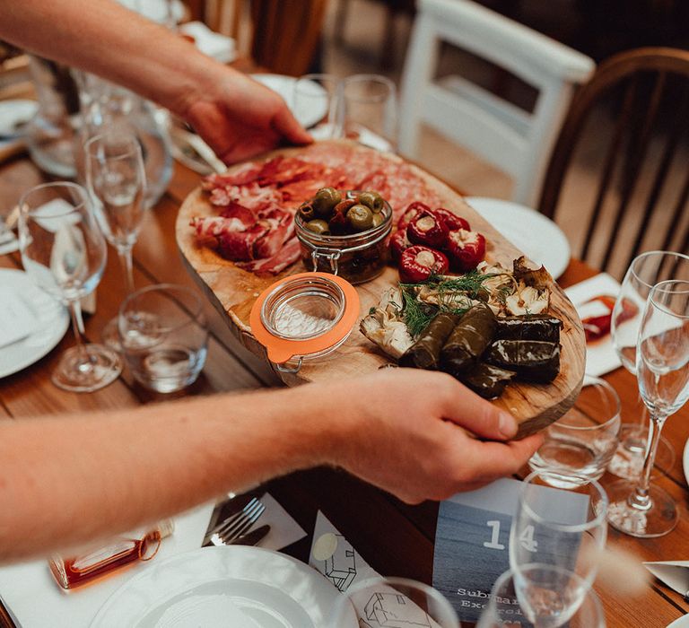 Cured wedding meats with olives and stuffed peppers on wooden board 