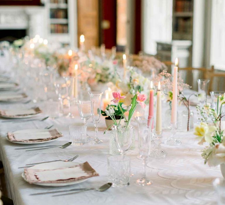 Classic wedding tablescape with pink tapered candles, white tablecloth and spring florals at St Giles House