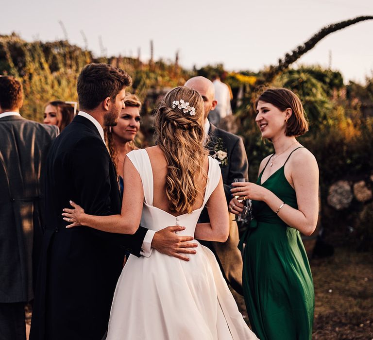 bride in a princess wedding dress embracing her husband with a half up half down wedding hairstyle 