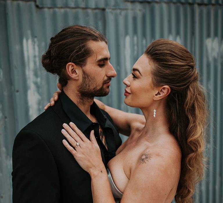 Groom in black wedding suit with bride in strapless gown with half up half down wedding hair 