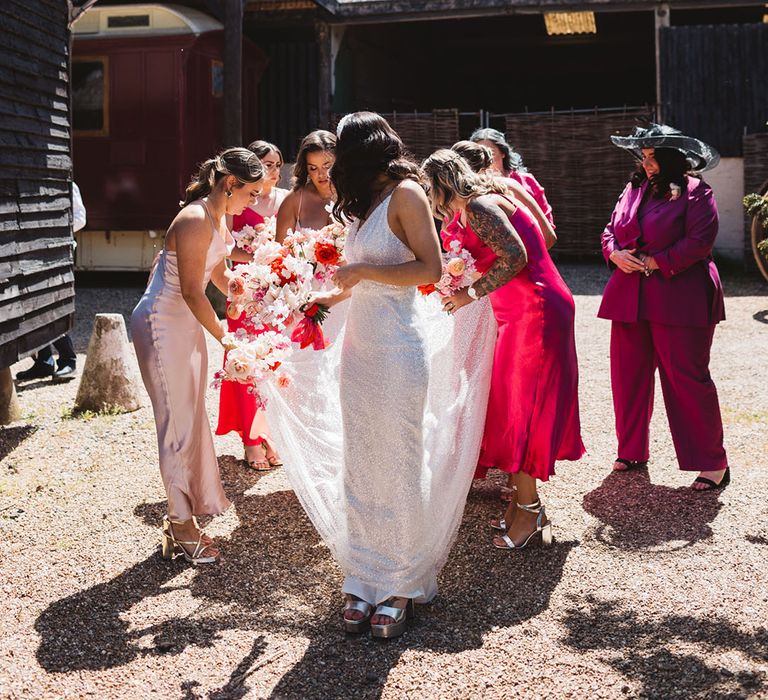 Bride in Made With Love wedding dress with bridal party in mismatched pink satin bridesmaid dresses 