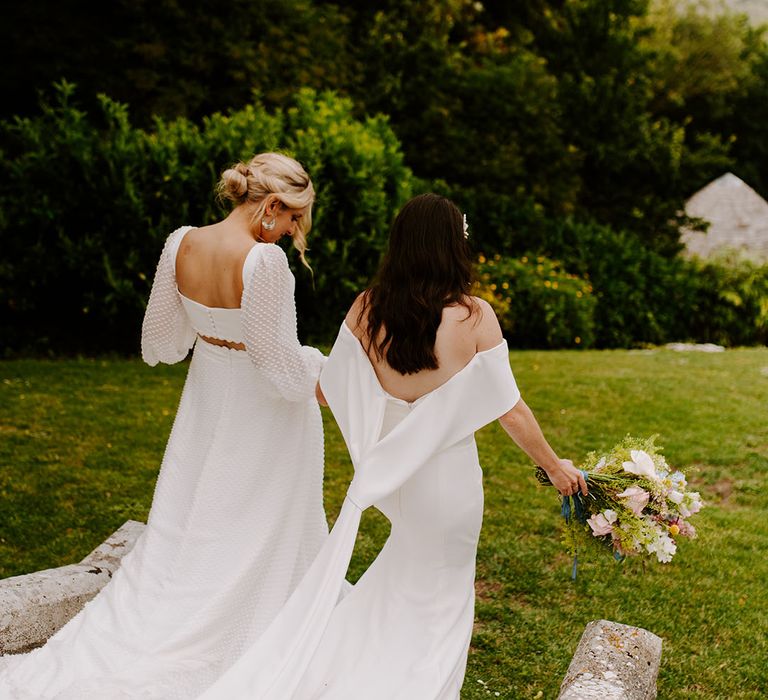 Brides walking around their Dorset wedding venue together at castle wedding 