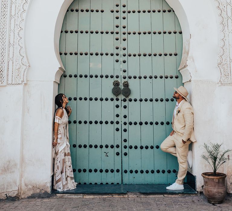 Marrakech destination wedding with the bride and groom posing in front of the blue door 