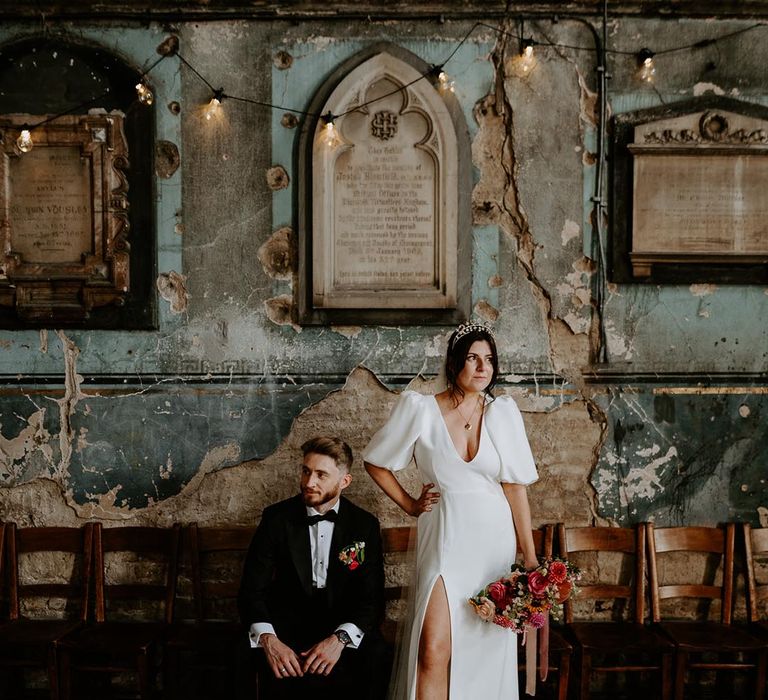 Groom in black tuxedo with bride in puff sleeve gown with crown 