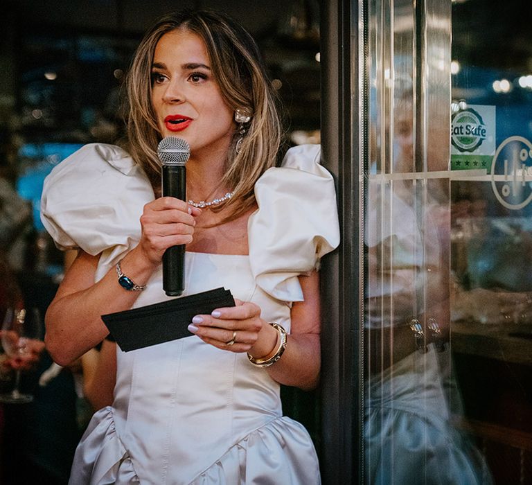 Bride in puff sleeve wedding dress making speech 