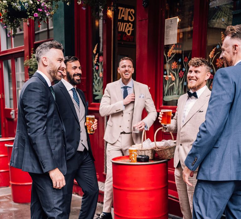 The groom and groomsmen enjoy drinks at the pub before the wedding 