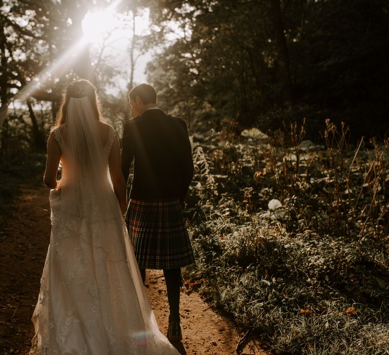 Bride and groom walk hand in hand through Perthshire 