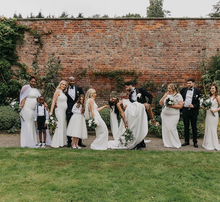 Wedding party portrait with white high street bridesmaid dresses and tuxedos 