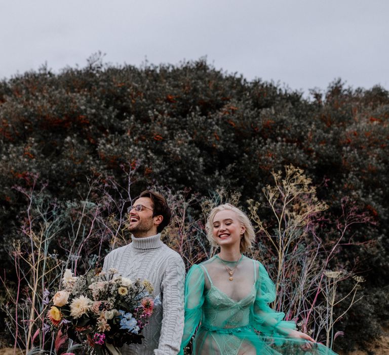 Stylish bride in a all in one and sheer wedding dress for a casual beach elopement 