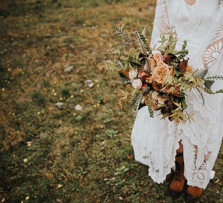 Bride carries floral bouquet in the Lake District