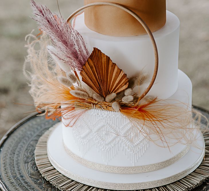 4-tier wedding cake complete in white and orange with Macrame detailing