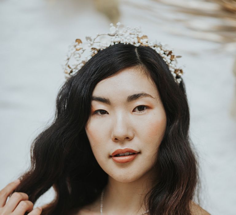 The bride wearing white and gold wedding accessories