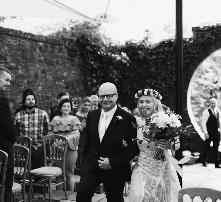 Bride in Grace Loves Lace Wedding Dress, single tier cathedral length veil and flower crown holding pink and white rose bouquet walking with father down the aisle