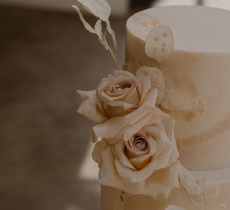 Two tiered off white marble effect wedding cake with rose decoration and gold leaf detailing by Bohemian Bakehouse